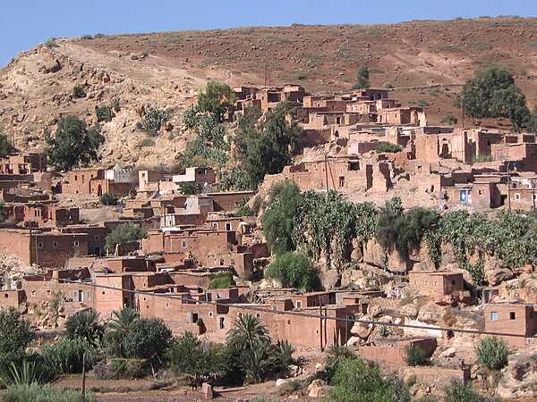 Village in the High Atlas Mountains of southern Morocco. The reddish (oxidized) soils lend their color to the brickwork throughout the village.