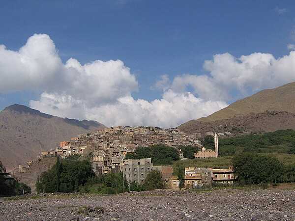 A village almost completely engulfs a steep hill in the High Atlas Mountains of southern Morocco.