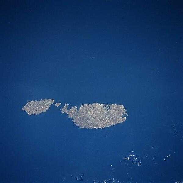Although small in size (316 sq km; 122 sq mi), the independent republic of Malta is strategically located midway between the Strait of Gibraltar and the Suez Canal in the Mediterranean Sea. The country is made up of three inhabited islands that are visible in this image: the island of Malta, the largest, Gozo, and Comino, the smallest (situated between the two larger islands). The capital and largest city, Valletta, is mainly built around a rocky peninsula, arrow-shaped peninsula extends northeast between two natural harbors (small, narrow, dark features). The geological faulting in this area has produced numerous fine natural harbors around the periphery of Malta. Although the islands are composed of sedimentary rocks, mainly limestone and clays, the alkaline soils provide fertile conditions for the well-established agricultural economy. Precipitation amounts can be a problem in that the islands average only about 32 cm (12 in) per year. Malta has few natural resources so the growth of tourism, especially since World War II, has gradually added to the Maltese economy. Photo courtesy of NASA.