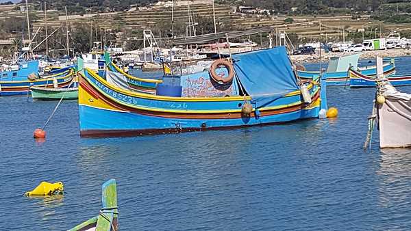 Some of the many colorful fishing boats in Marsaxlokk harbor. Known as luzzu, these boats are always painted in bright shades of blue, yellow, green, and red with a pair of eyes. The Eye of Horus or the Eye of Osiris, thought to be brought to Malta by the Phoenicians, is said to protect fishermen at sea. The boats are also used to ferry locals and tourists across the Grand Harbor.