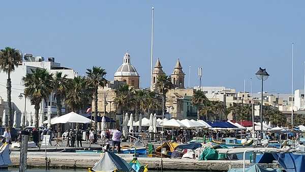 A view of Marsaxlokk, a traditional Maltese fishing village located on the southeast side of the island. The 1833 parish church in the background is dedicated to Our Lady of Pompeii and is built on the site of an original 17th century church.