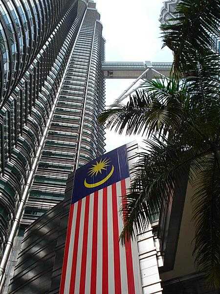Looking up one of the Twin Towers to the double-decker walkway. A Malaysian national flag hangs hear the entrance.