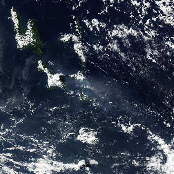 Vanuatu&apos;s Lopevi Volcano released a plume on 3 May 2007 (center of photo) that was captured by NASA&apos;s Aqua satellite. The US Air Force Weather Agency reported an extensive area of vog resulting from the volcanic eruption. When gases from a volcano - particularly sulfur dioxide - react with oxygen, water, dust, and sunlight, volcanic smog (or vog) results. Besides Lopevi and its neighboring islands, this image shows the volcanic plume blowing westward away from the volcano. The plume appears as a small, mostly opaque puff of gray-beige. The resulting area of vog, which appears as a more transparent, dingy-gray haze, dwarfs the diminutive plume. Lopevi is a stratovolcano composed of alternating layers of solidified lava, hardened ash, and volcanic rocks. One of the island nation&apos;s most active volcanoes, this volcanic island is only about 7 km (4 mi) wide. Eruptions have been recorded at Lopevi since the middle of the 19th century. Vanuatu&apos;s two major islands of Espiritu Santo and Malakula appear in the upper left. Image courtesy of NASA.