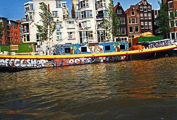 Colorful coffee shop barge moored on an Amsterdam canal.