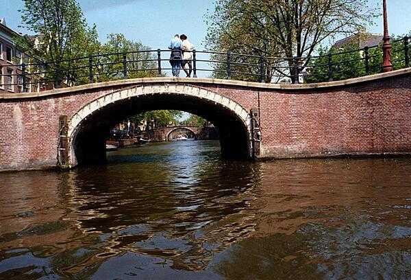 A series of similar-looking bridges spanning an Amsterdam canal.