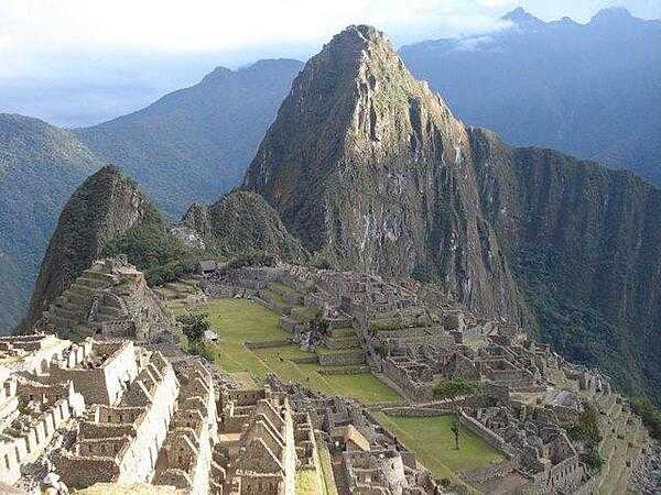 Many of the former housing units of the city of Machu Picchu are visible in the foreground of this image.
