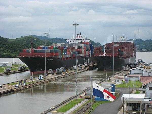 Two container ships passing through locks of the Panama Canal.