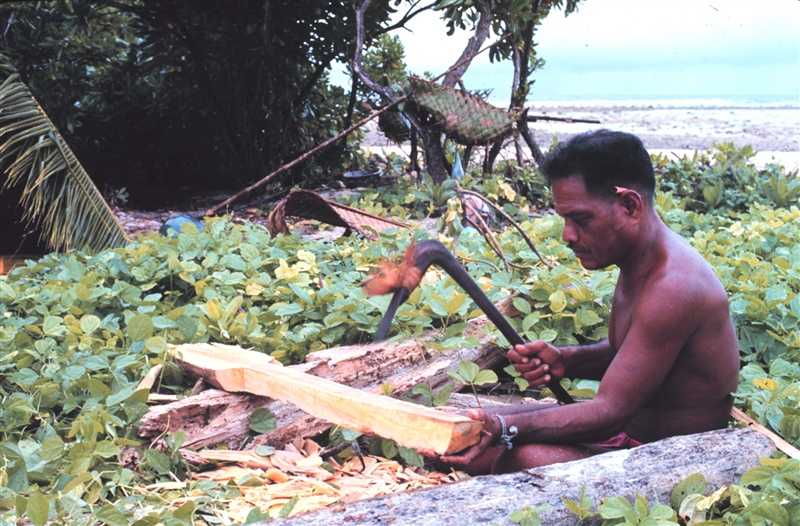 Native Micronesian making a paddle with an adze for his outrigger canoe (wa) on the island of Tobi. Image courtesy of NOAA / James P. McVey.