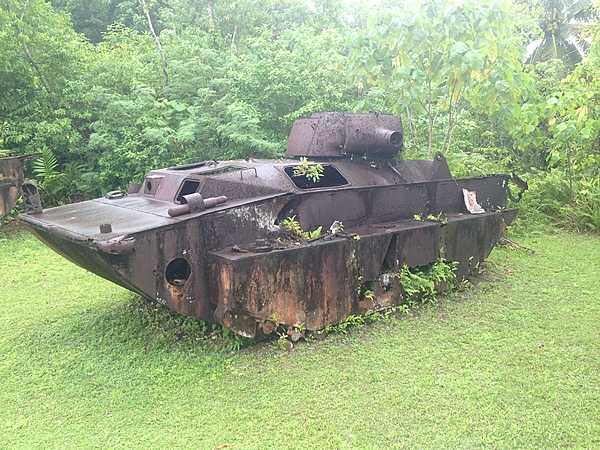 The remains of a Japanese tank starting to be overtaken by jungle foliage.