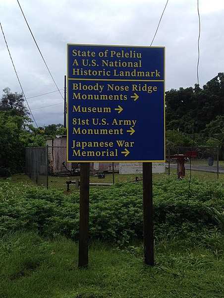 Directional sign to many of the World War II Battle of Peleliu memorial sites. The battle was fought between the US and Japan from 15 September to 27 November 1944 on the Palauan island of Peleliu. US Marines of the 1st Marine Division, and later soldiers of the US Army's 81st Infantry Division, fought to capture the airstrip on the small coral island. The casualty rate exceeded that of all other US amphibious operations during the Pacific War causing the fighting there to be described as, "the bitterest battle of the war for the Marines.”