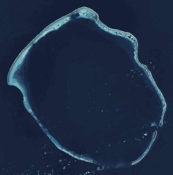 Satellite image of Enewetak Atoll. Enewetak Island after which the entire atoll is named is actually the southernmost island at the bottom right. The crater formed by the Ivy Mike nuclear test may be seen near the north cape of the atoll, with the smaller Castle Nectar crater adjoining it. Image courtesy of NASA.
