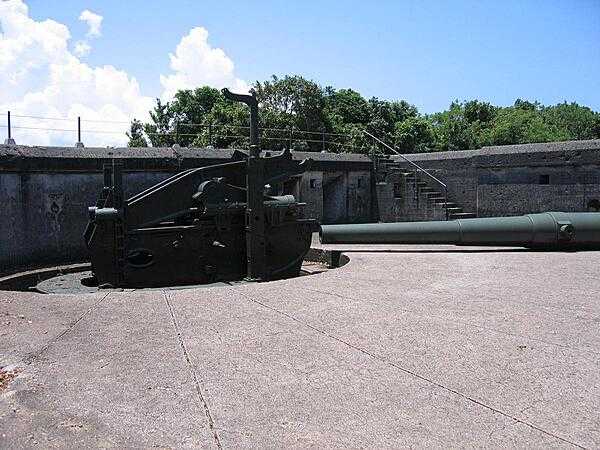 A 10-inch coast artillery gun and a &quot;disappearing&quot; mount emplaced in Battery Grubbs on Fort Mills (Corregidor). This type of mount is designed to employ a hinged counterweight to raise the gun for firing above the parapet of the gun emplacement and then to recoil back and down under cover for reloading. Fort Mills had 23 batteries with 56 coast artillery guns and mortars, of which six batteries were equipped with disappearing mounts. In addition, there were 13 anti-aircraft batteries with 76 guns.