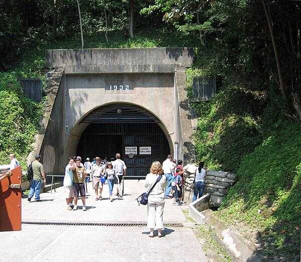 East entrance to the Malinta Tunnel complex on the island of Corregidor. Constructed by the US Army Corps of Engineers between 1922 and 1932, it was used for bomb-proof storage, as a command center, and a 1,000-bed hospital. The main east-west tunnel is 253 m (830 ft) long and 7.3 m (24 ft) wide, with 24 lateral tunnels, each about 49 m (160 ft) long and 4.6 m (15 ft) wide. A double track electric railway ran down the main tunnel. General Douglas MACARTHUR&apos;s headquarters and the offices of President Manuel L. QUEZON of the Philippines Commonwealth were located in laterals just inside this entrance.