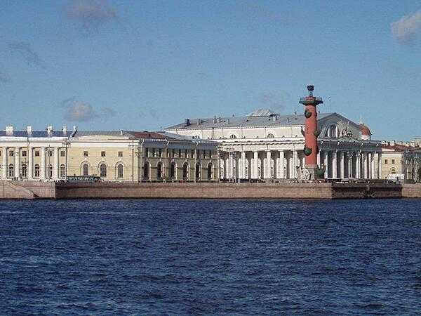 The Old Saint Petersburg Stock Exchange (white building) and one of its flanking Rostral Columns overlooking the inner harbor of the city.
