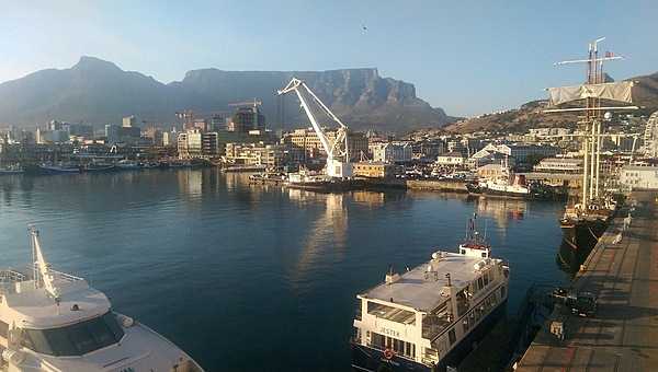 Cape Town waterfront. Pleasure boats, ferries, and cranes fill the harbor.