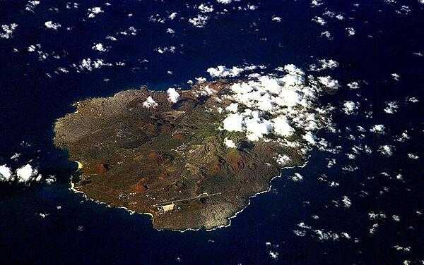 An oblique view of rugged Ascension Island, which is is barren in many places and has no indigenous human population. Instead the residents of the island are there because of Ascension&apos;s main industry: communications. The island has a long history as a communications hub for telephone and radio communications and as a base for satellite tracking stations, including a NASA station built in the 1960s that no longer operates. The European Space Agency operates a tracking station for its Ariane spacecraft on the eastern side of the island. 

Ascension Island is one of the most important breeding grounds for seabirds in the tropical Atlantic Ocean. The population of seabirds has been under threat since the first humans sailed up to the island in the 1500s. The ships accidentally introduced black rats, which overran the island, until cats were introduced to curb the rat population. The feral cats have decimated the bird populations, and in fact, are probably responsible for the extinction of two of the islands native land birds. A restoration project is underway to control the cat population and revive the seabirds. Image courtesy of NASA.
