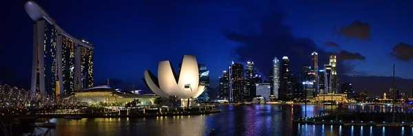 A night-time panorama of Marina Bay  featuring (on the left) the Marina Bay Sands Hotel, representing a ship on three towers, and the ArtScience Museum which resembles a lotus blossom.