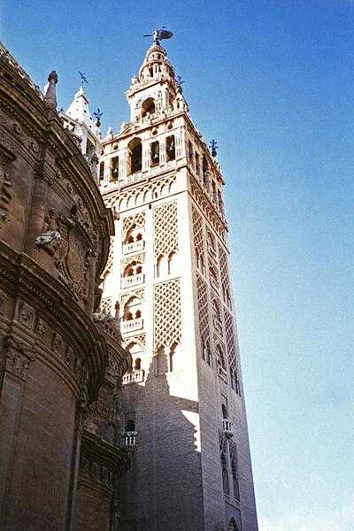 La Giralda, one of the two bell towers of the Catedral de Santa Maria de la Sede (Cathedral of Saint Mary of the See) at Seville. The lower two-thirds of the structure are a former minaret.
