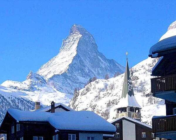 The Matterhorn towers over the roofs of Zermatt; at 4,478 m (14,688 ft), is one of the highest peaks in the Alps.