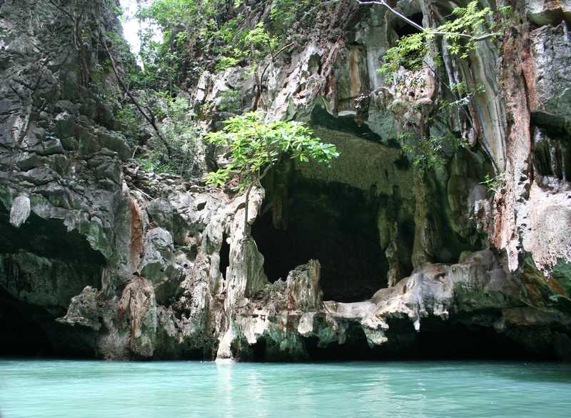 Phang Nga Bay, off the Andaman Sea near Phuket, is stunning collection of limestone islands.  Over time, the seawater has eroded the lower rock faces, creating caves, overhangs, and rock ribbons. The erosion also creates numerous inlets as shown in the photo.