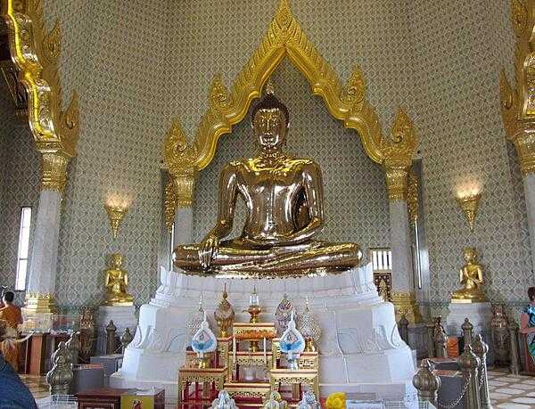 The Phra Sukhothai Traimit Golden Buddha in Bangkok, Thailand, is the largest golden buddha statue in the world. Made of pure gold, it is 3 m (9.8 ft) tall and weighs 5.5 tons (5,500 kg).  The Buddha was probably constructed in the 13th or 14th centuries and, at some point, was covered in layers of stucco and colored glass to conceal its true value from thieves. In 1954, while being relocated to a new site, the Buddha was dropped, and part of the covering broke, revealing the gold underneath. In 2010, the Golden Buddha was moved to a new building at the Wat Traimit Temple.