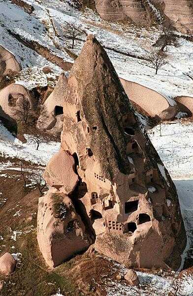 Distinctively shaped volcanic cones in the Cappadocia region of Turkey were shaped by centuries of wind and rain erosion. The soft rock is easily carved and hardens like concrete when exposed to the air. Many of these structures have been transformed into domestic dwellings.