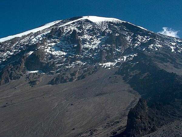 Mt. Kilimanjaro in Tanzania, Africa’s highest mountain and the world’s tallest freestanding volcano, is 5,895 m (19,341 ft) high. The origin of its name supposedly is a combination of the Swahili word kilima meaning “mountain” and the KiChagga word njaro, loosely translated as “whiteness” giving the name “White Mountain.” Mt. Kilimanjaro became a UNESCO World Heritage Site in 1987 and a Natural Wonder of Africa in 2013.View of Kilimanjaro Peak.