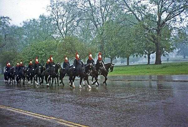 An element from The Blues and Royals, in their distinctive blue rain capes, passing along a damp London street. The Blues and Royals are part of the Household Cavalry Regiment performing ceremonial duties on state and royal occasions as well as an armored reconnaissance unit taking part in active military operations around the world. As one of the senior regiments of the British Army, the lineage of The Blues and Royals includes The Royal Horse Guards (Blues) and The Royal Dragoons (1st Dragoons) dating back to the Restoration Period of 1660-1661.