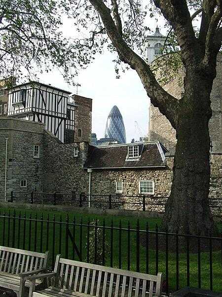 The tip of the distinctive 30 St Mary Axe Building (40 stories; commonly referred to as The Gherkin) as seen from the courtyard of The Tower of London fortress.