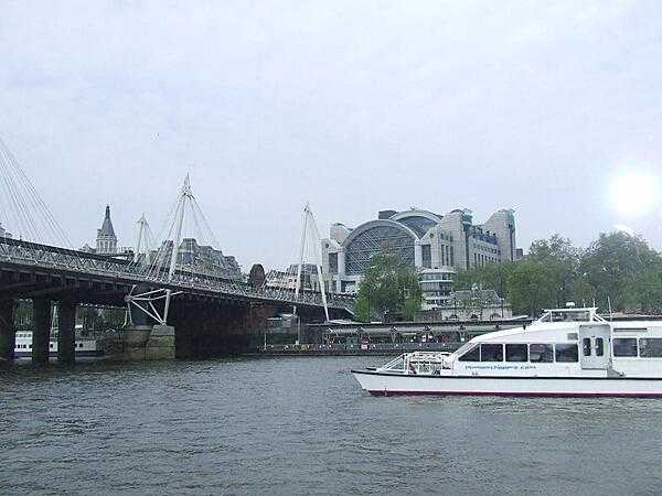 The Charing Cross Railroad Station in London. The Hungerford Bridge that leads to the station is flanked by two cable-stayed pedestrian bridges that share the railroad bridge&apos;s foundation piers and which are officially named the Golden Jubilee Bridges.