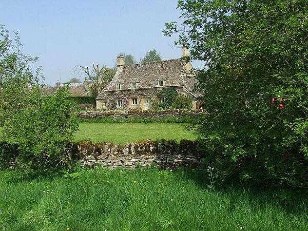 Typical Cotswolds hills cottage and dry stone walls.