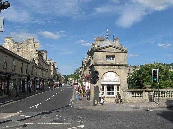 View across the Pulteney Bridge, which spans the River Avon in Bath, county Sommerset, England. The bridge is lined by shops on both sides.