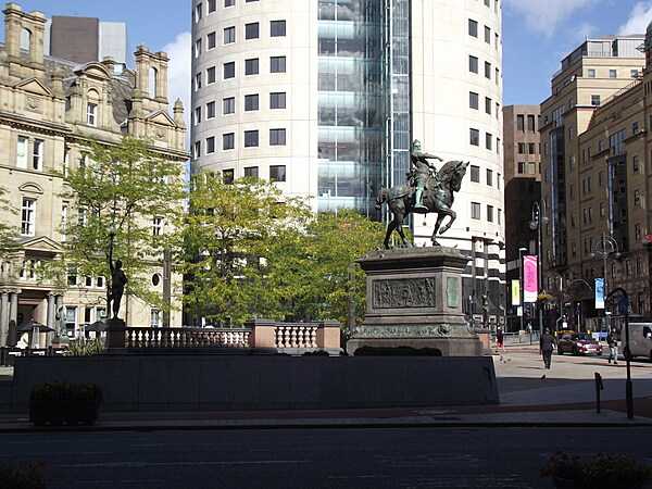 A view of City Square in Leeds. The statue is of The Black Prince, Edward of Woodstock. On the left is the Old Post Office; the round building in the background is called No 1 City Square.