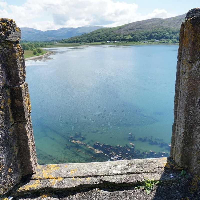 A view from the battlements of Castle Stalker onto Loch Laich in Scotland. The island castle is one of the best-preserved medieval tower houses to survive in western Scotland.