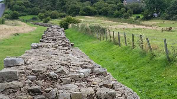 A view from the top of a section of Hadrian's Wall. The defensive fortification was built by the Romans over six years beginning in A.D. 122 and then strengthened in subsequent decades. Named after the emperor who ordered its construction, the barrier secured the northwest section of the empire from barbarians. The 117.5-km (73-mi) wall stretches across England from Wallsend in the east to Solway Firth in the west and was designated a UNESCO World Heritage site in 1987.