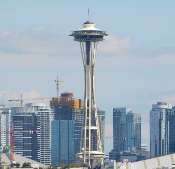 The Seattle Space needle officially opened to the public on 21 April 1962 as part of the  Century 21 Exposition, a space-aged themed world's fair. The iconic  steel structure stands 184 m (605 ft) tall and offers 360-degree views from three main areas: an indoor observation deck, an open-air viewing area located at 158 m (520 ft), and the world's first revolving glass floor located at 152 m (500 ft) above the ground. In 1999, the Space Needle was designated an official landmark.