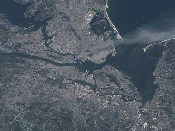Visible from space, a smoke plume rises from the Manhattan area after two planes crashed into the towers of the World Trade Center. This photo was taken of metropolitan New York City (and other parts of New York as well as New Jersey) the morning of 11 September 2001. Image courtesy of NASA.