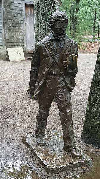 The statue of Henry David Thoreau in front of his reconstructed cabin at Walden Pond, near Concord, Massachusetts.