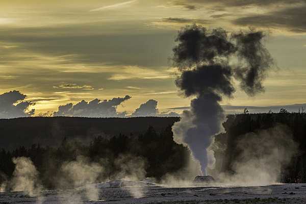 Steam rises from Lion Geyser at sunset. Note steam from other geysers in the background. Image courtesy of the US National Park Service/Neal Herbert.