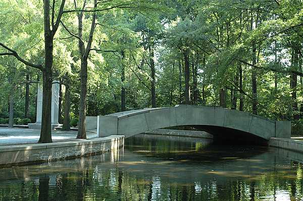 A stone footbridge, moat, and willow oaks at the presidential memorial on Theodore Roosevelt Island, Washington, D.C. Photo courtesy of the National Park Service.