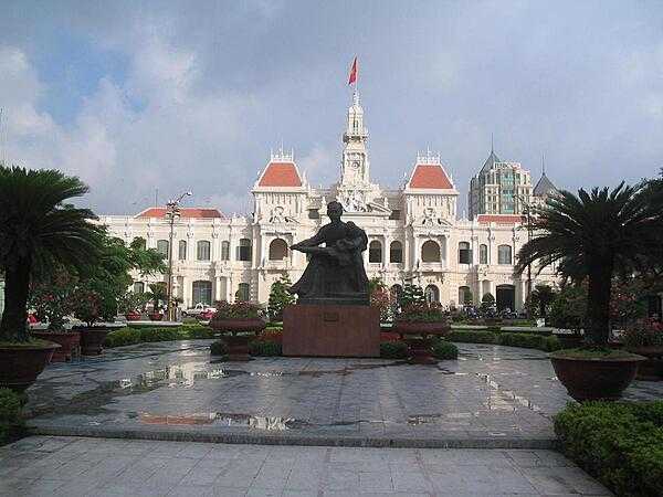 Statue of Ho Chi Minh reading to a child in front of the City Hall in Saigon (Ho Chi Minh City). Built by the French between 1898 and 1908, the beautifully ornamented structure is officially known as the Ho Chi Minh City People&apos;s Committee Building and is not open to the public.