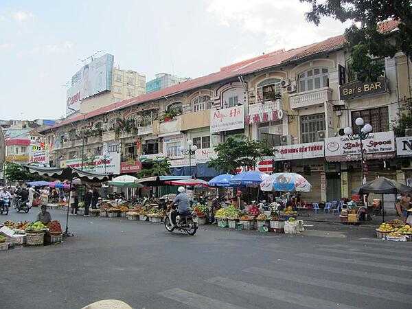 Typical market in Saigon (Ho Chi Minh City), the buildings in the background are from the French colonial era.