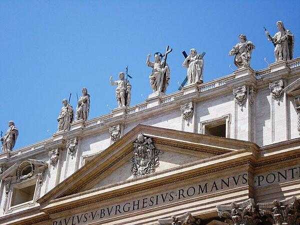 A statue of Christ and some of his apostles on the facade of St. Peter&apos;s Basilica.