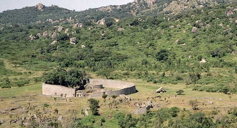 Zimbabwe takes its name from the Kingdom of Zimbabwe (13th-15th centuries) and its capital, Great Zimbabwe (pictured). Built largely of stone by the Shona people, this 7.22 sq km (2.79 sq mi) city is believed to have housed the royal palace and was home to 18,000 people. The city was abandoned in 1450, possibly due to a decline in trade. Today Great Zimbabwe is a national monument, and it became a UNESCO World Heritage site in 1986. The bird on the Zimbabwean flag is adapted from the soapstone figures found at the site and is associated with the royal totem of the ancient monarchs.